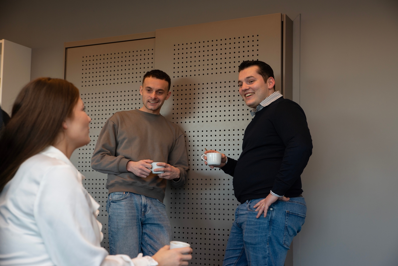 Man en vrouw achter een balie die samen naar een laptop kijken